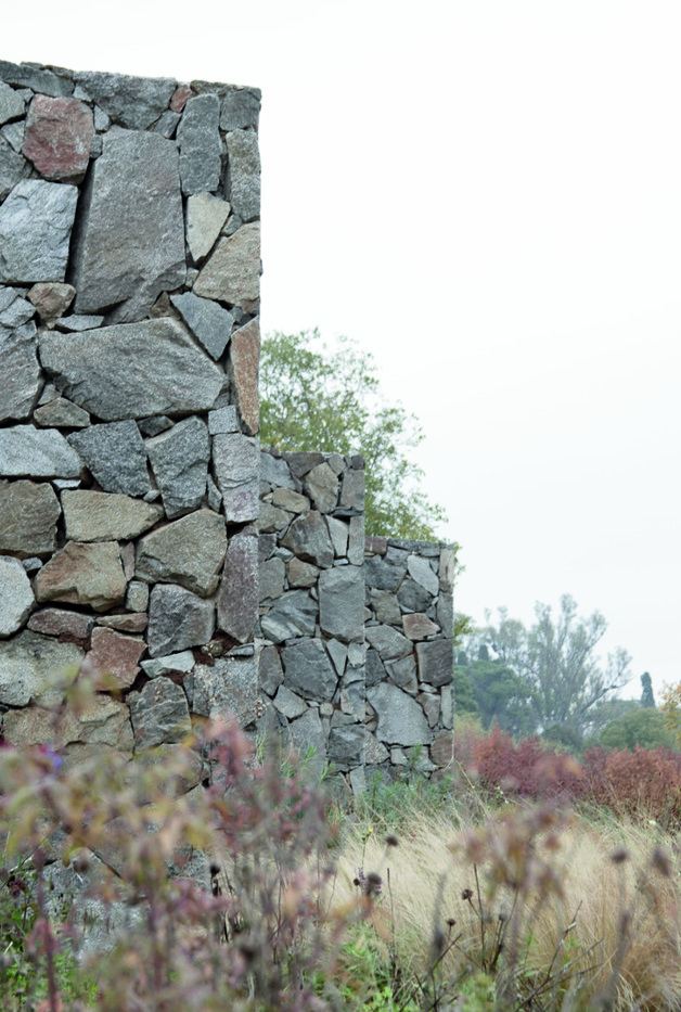 Muro de piedra y pastizal con niebla